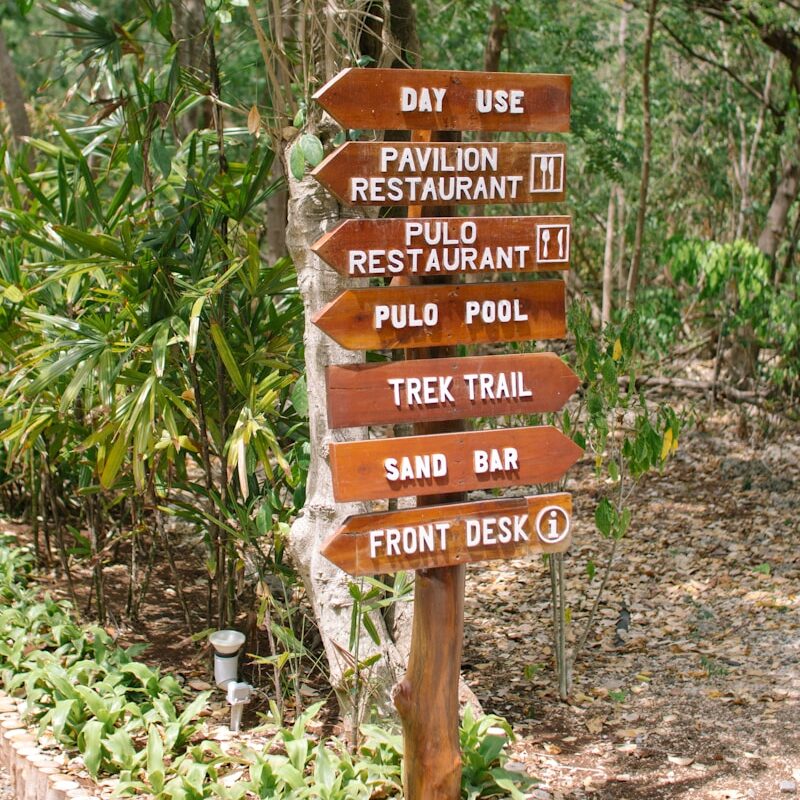 A wooden sign sitting on the side of a road