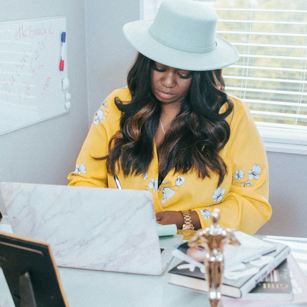 a woman sitting at a desk working on a laptop